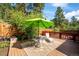Relaxing outdoor deck featuring a seating area with umbrella providing shade and comfort in the backyard at 7284 Willa Ln, Evergreen, CO 80439