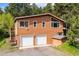 Two-story home boasts an attached garage, stairs to the deck, and is surrounded by lush greenery and trees at 7284 Willa Ln, Evergreen, CO 80439