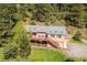 Two-story home nestled in a wooded area, featuring a large deck and ample outdoor space at 7284 Willa Ln, Evergreen, CO 80439