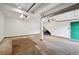 Spacious two-car garage with white walls, green door and concrete flooring provides secure parking and storage space at 7284 Willa Ln, Evergreen, CO 80439