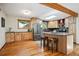 Charming kitchen boasts wood cabinets, stainless steel appliances, wood beam and an island with seating at 7284 Willa Ln, Evergreen, CO 80439