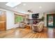 Cozy living room featuring a skylight, bay window, stone fireplace, and hardwood floors for a comfortable ambiance at 7284 Willa Ln, Evergreen, CO 80439