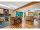 Bright living room showcasing skylight, wood floors, beam, kitchen island and seamless flow at 7284 Willa Ln, Evergreen, CO 80439