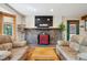 Comfortable living space with a stone fireplace and stylish seating beneath the ambient skylight at 7284 Willa Ln, Evergreen, CO 80439