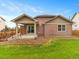 Exterior view of a home with a covered patio, a stone bed, and a well-manicured backyard at 3838 Brush Rd, Castle Rock, CO 80108