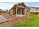 Exterior view of a home with a covered patio and stepping stones leading to a grassy yard at 3838 Brush Rd, Castle Rock, CO 80108
