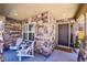 Inviting covered front porch with stone accents, seating, and a welcoming entryway at 3838 Brush Rd, Castle Rock, CO 80108