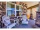 Comfortable seating on a charming front porch with stone details and large window at 3838 Brush Rd, Castle Rock, CO 80108