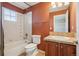 Traditional bathroom includes a shower-tub combo, vanity with sink, and decorative tile at 13075 Tamarac St, Thornton, CO 80602
