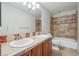 Bathroom features double sinks, tile backsplash, and a shower-tub combo with tile surround at 13075 Tamarac St, Thornton, CO 80602