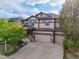 Two-story home with a three-car garage, stone accents, a manicured yard, and inviting curb appeal at 13075 Tamarac St, Thornton, CO 80602