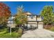 Charming two-story home featuring a stone facade, two-car garage, and well-maintained front yard with mature trees at 13075 Tamarac St, Thornton, CO 80602