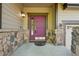 Close-up of a front door, featuring stone accents, a decorative light fixture, and a welcoming entrance at 13075 Tamarac St, Thornton, CO 80602