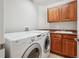 Laundry room features modern washer and dryer, sink and wooden cabinets at 13075 Tamarac St, Thornton, CO 80602