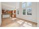 Bright living space with hardwood floors, large windows, and open access to the kitchen area at 13075 Tamarac St, Thornton, CO 80602