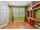 Home office with custom built-in shelving, desk space, and hardwood floors at 13075 Tamarac St, Thornton, CO 80602