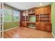 Home office with custom built-in shelving, desk space, and hardwood floors at 13075 Tamarac St, Thornton, CO 80602