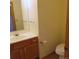 Bathroom with wood vanity and floors, white sink and toilet, and a framed mirror offers a clean design at 473 N Banner St # C, Elizabeth, CO 80107