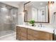 Elegant bathroom with a double vanity, decorative mirror and glass-enclosed shower at 852 Pontiac St, Denver, CO 80220