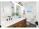 Bathroom boasts dual sinks, wood cabinets, and a well-lit vanity with wall mirrors at 852 Pontiac St, Denver, CO 80220