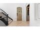 Welcoming entryway with herringbone floors, rustic wooden door, and staircase with black iron railing at 852 Pontiac St, Denver, CO 80220