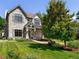 Charming stone-clad two-story home with a well-manicured lawn, mature trees, and beautiful landscaping at 852 Pontiac St, Denver, CO 80220
