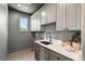 Laundry room with ample cabinet space, a utility sink, and a bright window view at 852 Pontiac St, Denver, CO 80220