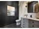 Stylish powder room featuring dark walls and black and white geometric tile flooring at 852 Pontiac St, Denver, CO 80220