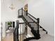 Elegant staircase with black railings and a view into a bright, stylish living room at 852 Pontiac St, Denver, CO 80220