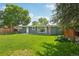 Green home with a lush lawn, fenced yard, and mature trees, perfect for outdoor enjoyment at 6155 Carr St, Arvada, CO 80004