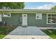 Backyard exterior featuring a white door, green siding, and a concrete patio at 6155 Carr St, Arvada, CO 80004