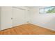 This bedroom features wood floors, a closet, a window, and white walls at 6155 Carr St, Arvada, CO 80004