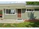 Close up of front door with a window to the left and green horizontal siding at 6155 Carr St, Arvada, CO 80004