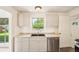 Bright kitchen with white cabinets, granite countertops, and stainless steel dishwasher at 6155 Carr St, Arvada, CO 80004