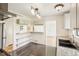 This kitchen features black tile flooring, bright white subway tiles, and a breakfast bar with shelving at 6155 Carr St, Arvada, CO 80004