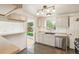Updated kitchen featuring stainless steel appliances, white cabinets, and granite countertops at 6155 Carr St, Arvada, CO 80004