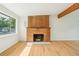 Bright living room featuring a brick fireplace, hardwood floors, and large windows at 6155 Carr St, Arvada, CO 80004