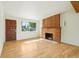 Bright living room with a brick fireplace, hardwood floors, and a large window at 6155 Carr St, Arvada, CO 80004