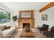 Bright living room featuring a brick fireplace, large window, and neutral tones at 6155 Carr St, Arvada, CO 80004