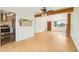 Open concept living room with hardwood floors, brick fireplace, and access to the kitchen at 6155 Carr St, Arvada, CO 80004