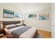 This staged bedroom features a bed, nightstands, lamps, and wood floors at 6155 Carr St, Arvada, CO 80004