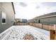 Snow-covered backyard with wooden fence at 47387 Lilac Ave, Bennett, CO 80102