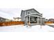 Two-story house with gray siding, covered porch, and wooden fence at 47387 Lilac Ave, Bennett, CO 80102