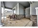 Covered front porch with rocking chairs and stone accents at 47387 Lilac Ave, Bennett, CO 80102