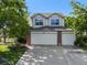 Inviting two-story home with a three-car garage, manicured lawn, and vibrant flower beds at 1010 Home Farm Cir, Denver, CO 80234