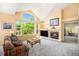 Cozy living room features large windows, a fireplace, and neutral carpet at 1010 Home Farm Cir, Denver, CO 80234