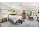 Bright main bedroom featuring multiple windows, a ceiling fan, and neutral carpet at 1010 Home Farm Cir, Denver, CO 80234