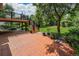 Outdoor patio with brick flooring and wooden deck steps, offering a space for entertaining and enjoying the backyard at 1010 Home Farm Cir, Denver, CO 80234