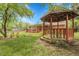 Secluded backyard showing a wooden gazebo, water feature with bridge and the rear of the brick home and patio at 1160 Johnson St, Lakewood, CO 80215