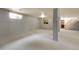 Finished basement with carpeting, painted support columns, and a window; stairs to the upper level are in the background at 1160 Johnson St, Lakewood, CO 80215